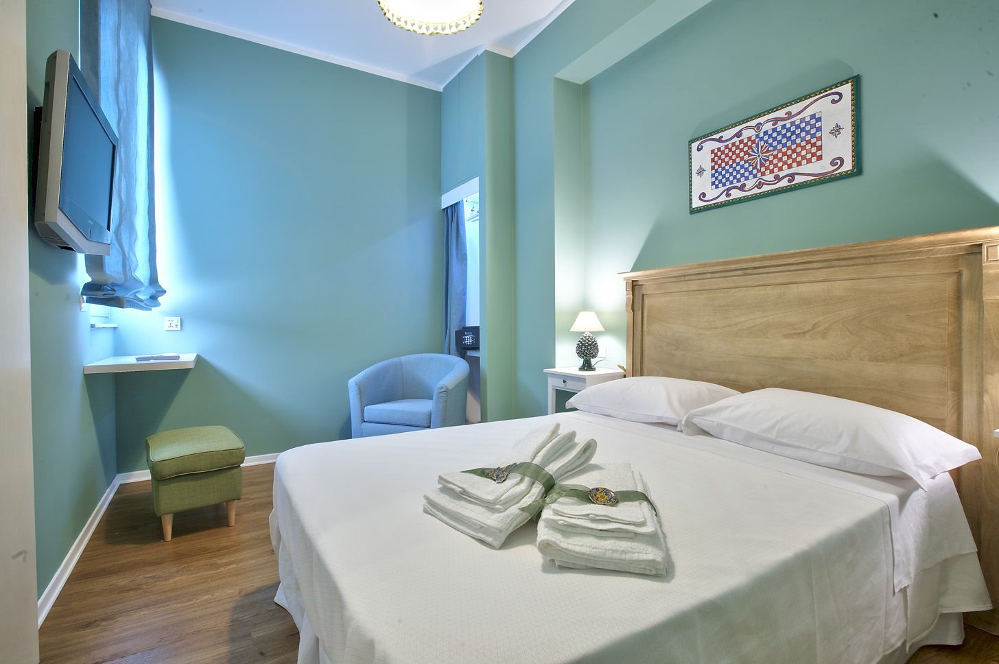 The Green Room with a light-wood headboard